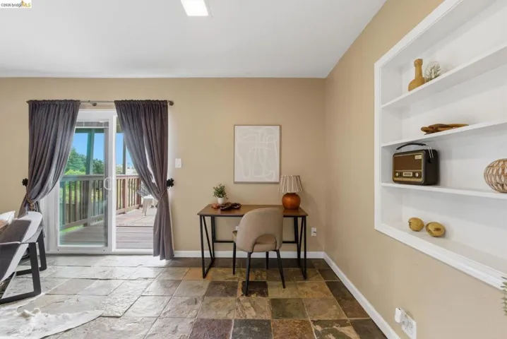 Interior room featuring multi-toned slate tile flooring and a sliding glass door providing exterior access