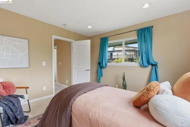 Carpeted room featuring a white interior door, recessed lighting, and a large window with white trim