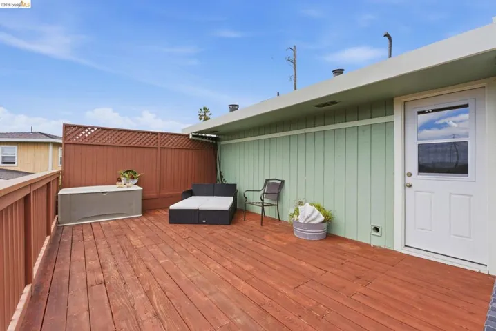 Expansive outdoor deck featuring wood flooring, a sturdy wood railing, and a lattice privacy screen