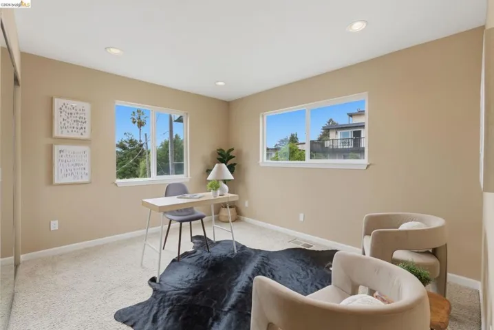 Carpeted room with recessed lighting and two large windows