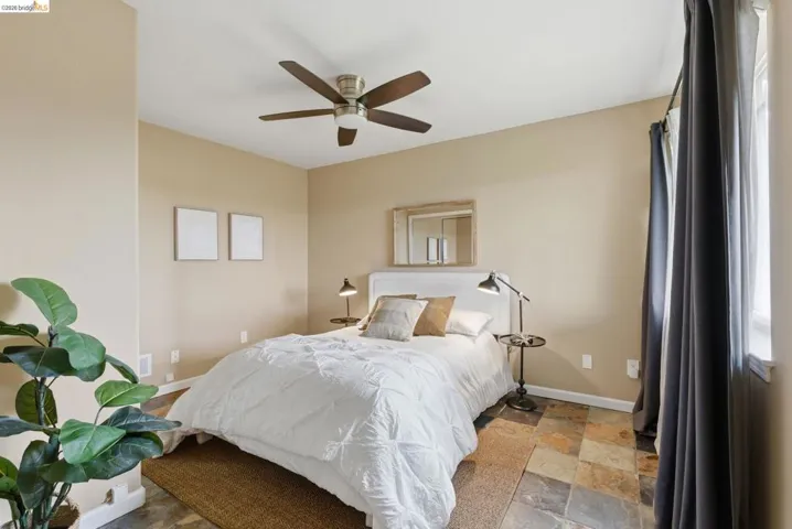 Bedroom featuring natural stone tile flooring and neutral wall tones