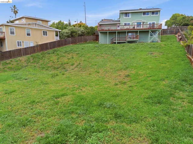 Expansive green space with an elevated property featuring a two-story residence