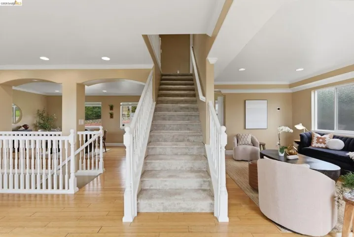 Central carpeted staircase with white balusters
