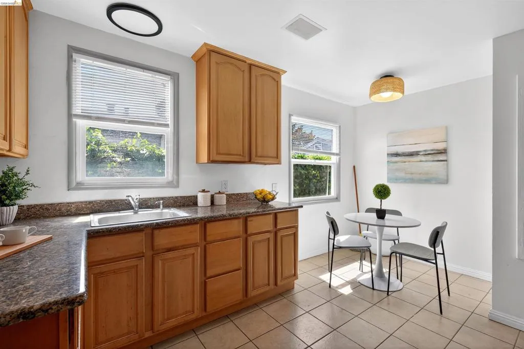 Kitchen featuring wood-finish cabinetry, speckled countertops, and a stainless steel sink with a single-handle faucet