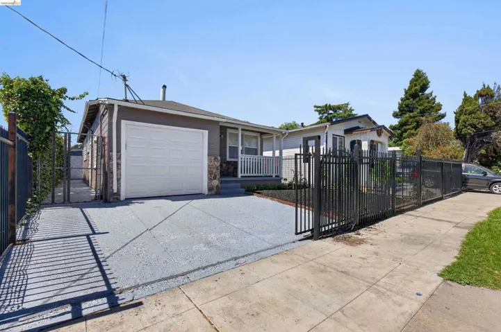 Paved driveway with black wrought iron fencing and gate