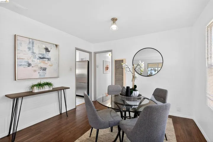 Open dining area featuring wood-finish flooring, white walls, and a ceiling-mounted light fixture