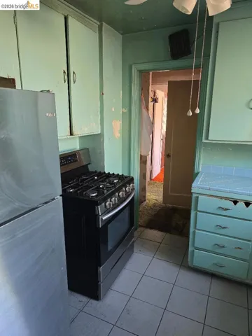 Kitchen featuring a gas range, tile flooring, and light blue cabinetry with a tiled countertop