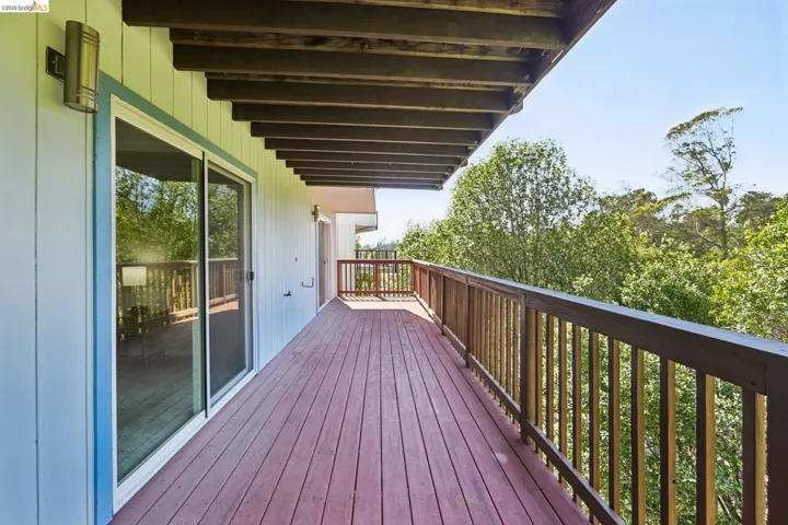 Expansive exterior deck featuring wood-finish decking and railing
