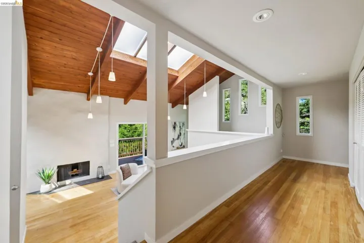 Upper-level landing featuring wood-finish flooring, recessed lighting, and multiple vertical windows