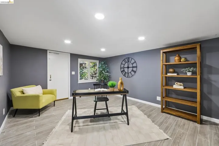 Recessed lighting illuminates this room featuring wood-finish flooring set in a herringbone pattern