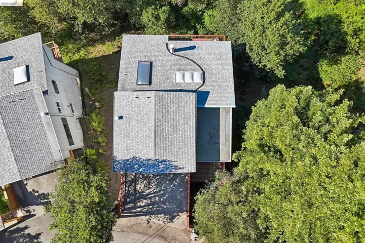 Architectural roof shingles on a multi-level structure, featuring multiple skylights and a covered carport area