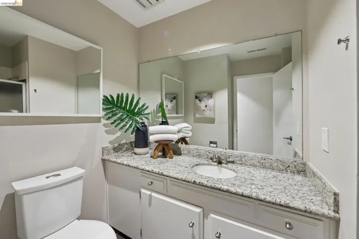 Vanity featuring a white undermount sink, a chrome faucet, and a light-toned speckled countertop