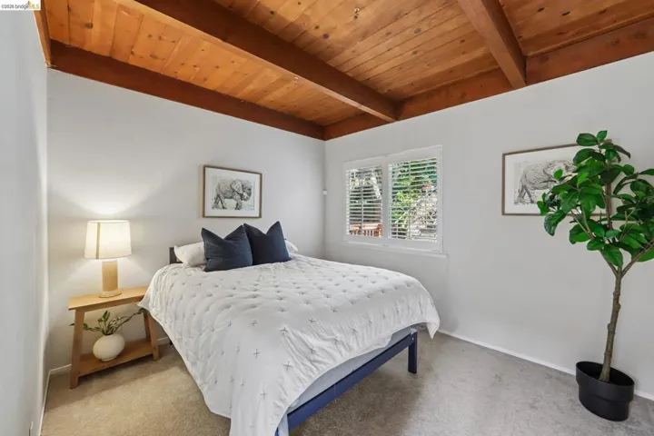 Exposed wood beam ceiling featuring natural wood paneling and recessed lighting