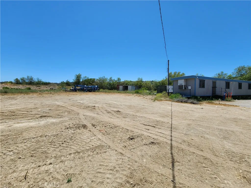 Building pad with office trailer located at the right side of the lot at the top of the driveway.