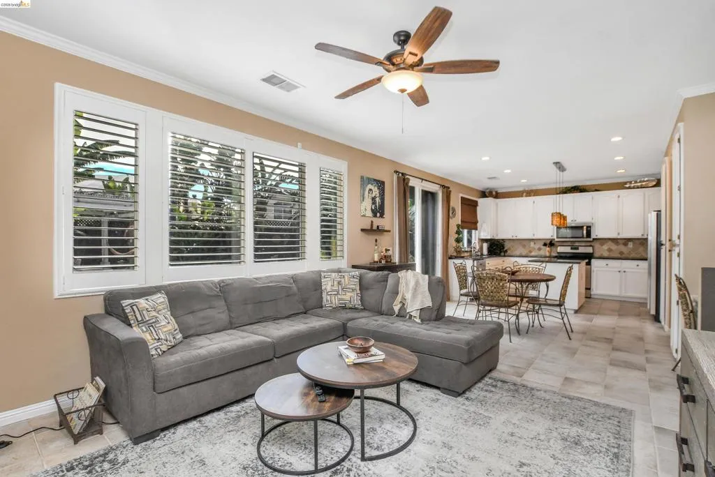 Open-concept living area with tile flooring and a ceiling fan