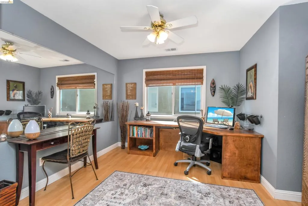 Light wood-finish flooring with a ceiling fan overhead