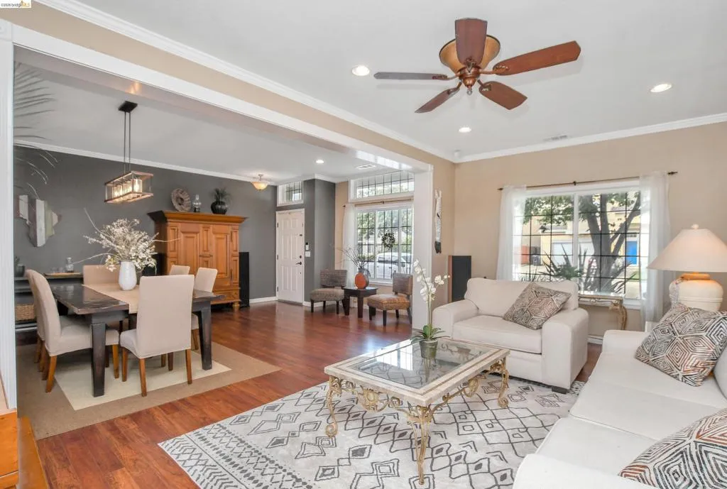 Open concept living area featuring wood-finish flooring, recessed lighting, and crown molding
