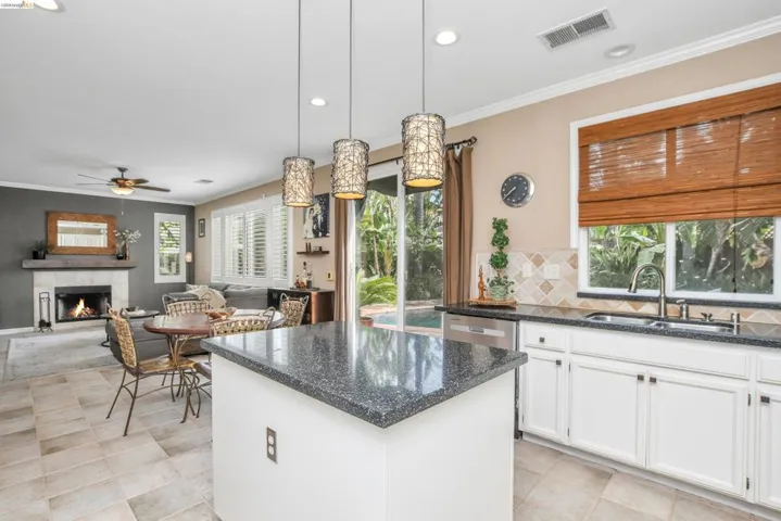 Kitchen island with dark speckled countertop and pendant lighting