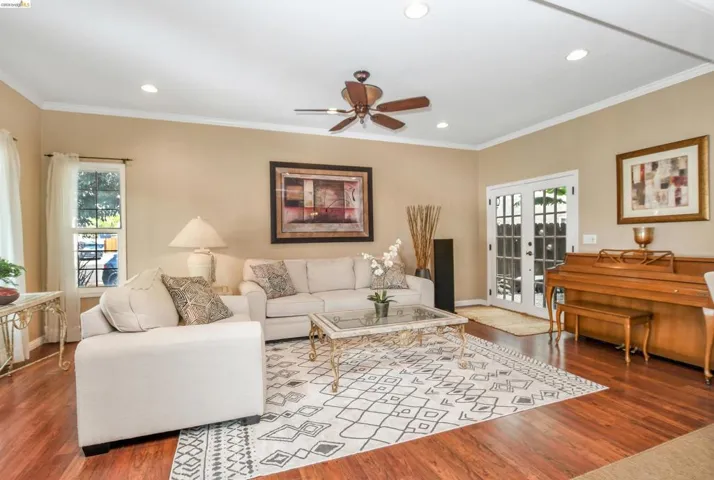 Spacious living area featuring wood-finish flooring, recessed lighting, and a ceiling fan