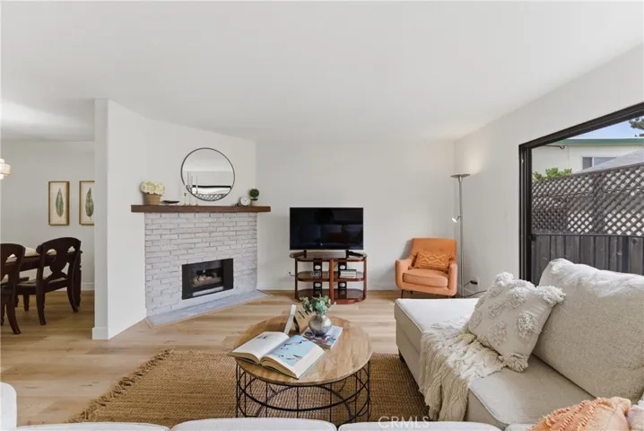 Living Room with updated floors, fireplace & balcony access