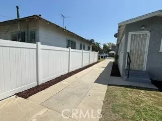 Newer vinyl fencing to Eastside of Lot  and view of long driveway from the backyard