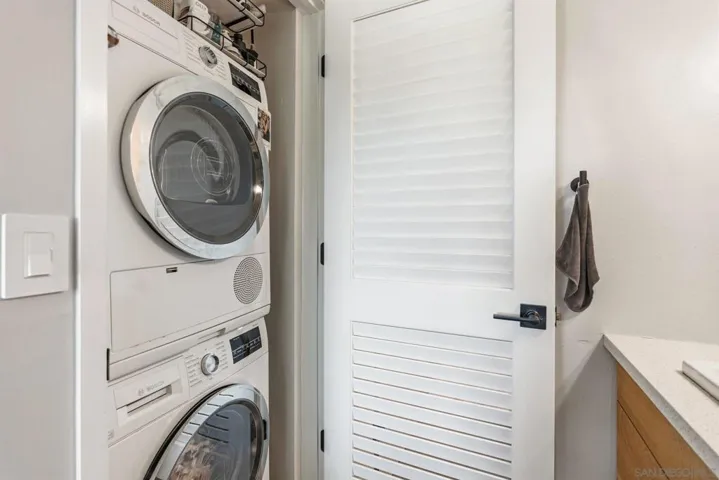 Laundry closet with stackable washer/dryer in primary bathroom