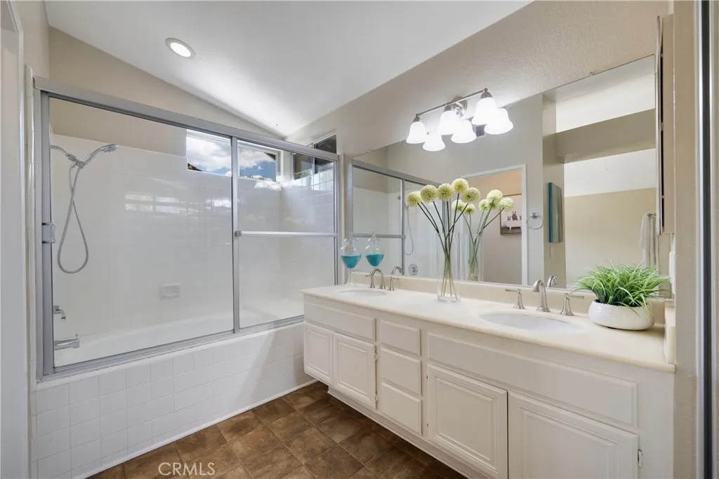 Upstairs primary bathroom has dual sinks & recessed lighting.