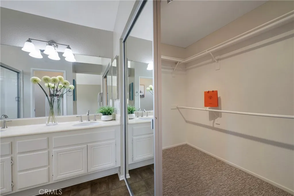 Sliding glass doors on walk in closet in primary bathroom.