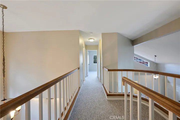 Top of stairway lands into catwalk that connects three additional bedrooms.