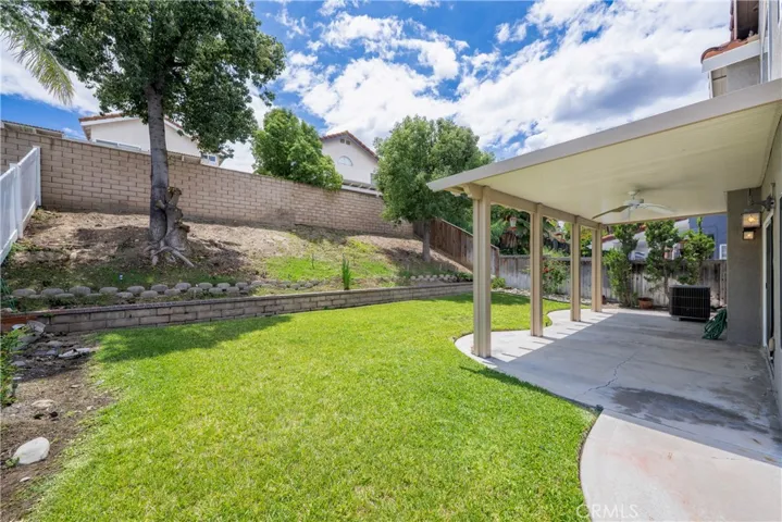 Covered back yard patio has a fan light.