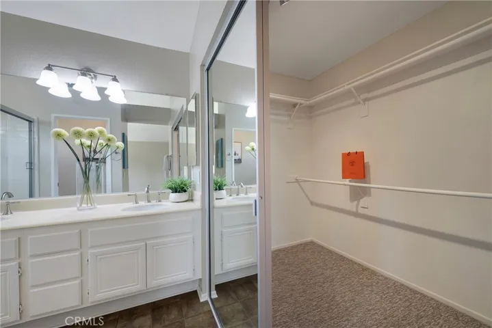 Sliding glass doors on walk in closet in primary bathroom.