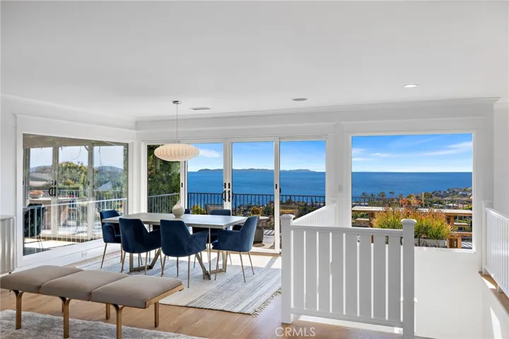 The living room is open to the dining room with stunning Catalina Island views. sliding doors leading to the expansive deck to enjoy the view.