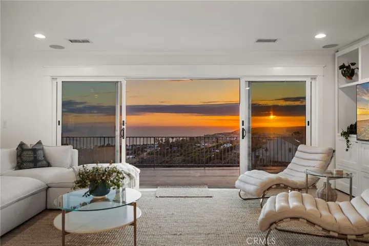 Stunning sunset view from the family room, with doors leading to the expansive deck that runs the length of the property.