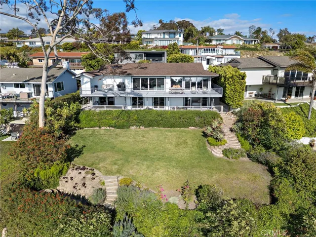 Looking towards the back of the property with a sprawling pool-sized lawn and professional landscaping and new hardscape.
