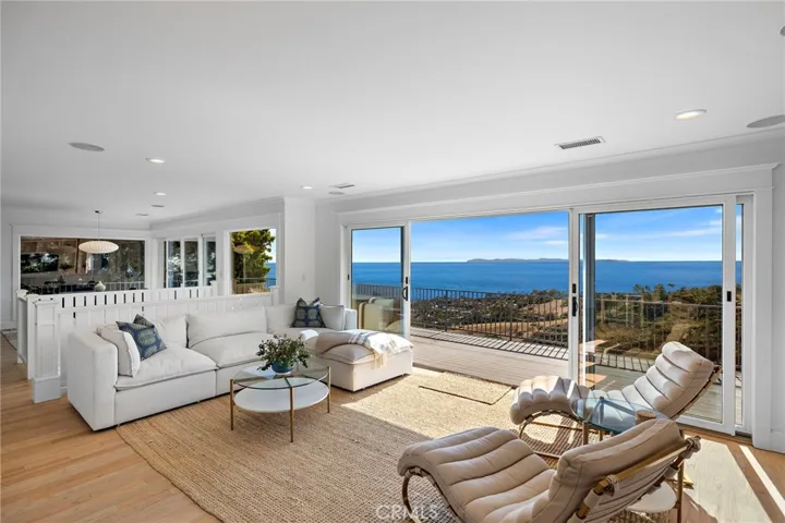 Family room with a wall of glass leading to the expansive deck. Looking towards the dining room. Wonderful open floor plan!