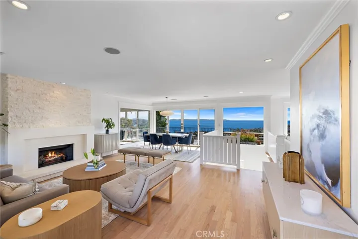 Refinished hardwood floors run throughout the upper level, encompassing a formal living room with a limestone fireplace finished with custom millwork and a slab surround.