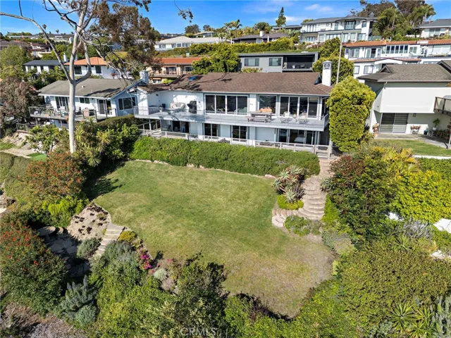 Looking towards the back of the property with a sprawling pool-sized lawn and professional landscaping and new hardscape.