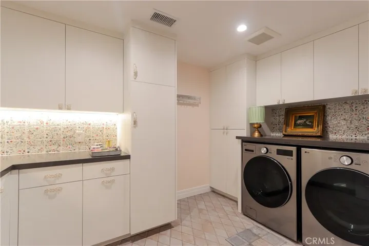 The impressive laundry room has substantial storage for today's busy family. Cheerful designer tile accents and yes, the sleek washer and dryer set is included!
