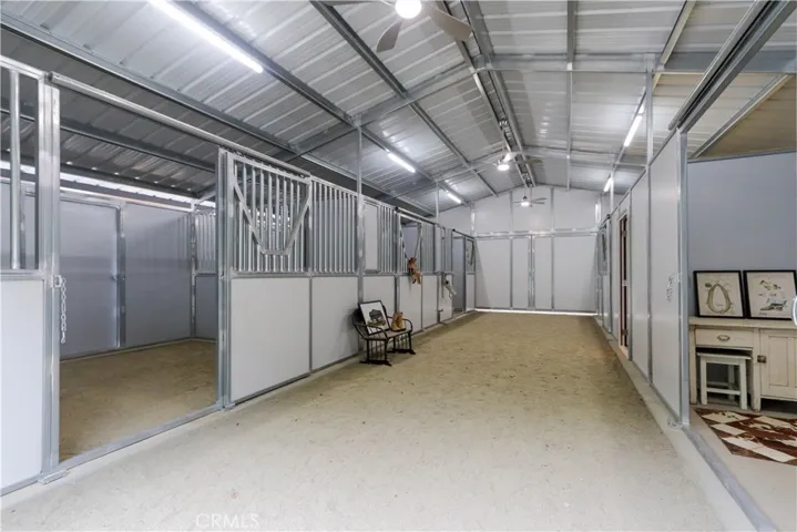 A brand-new, breezeway barn with a 6-stall configuration including 4 paddock stalls with individual turnouts, tack room and cement-floor feed room. App controlled lighting and ventilation, outdoor sink and dedicated horse wash area.