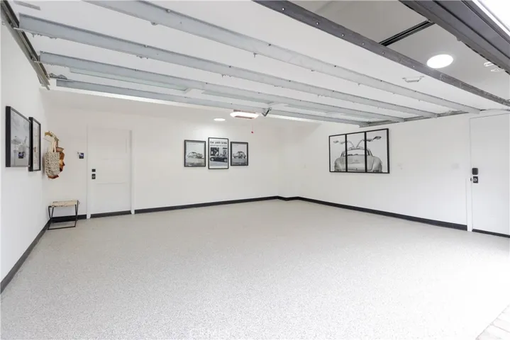 The immaculate garage with pristine epoxy floors and a polished finish offers both functionality and presentation for car enthusiasts. Plus direct entry to the walk-in pantry with drop station and built-in beverage cooler.