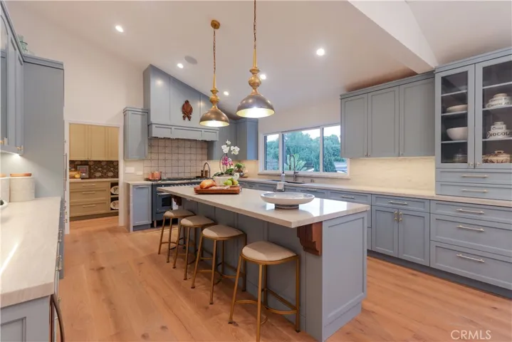 The breakfast bar center island is as functional as it is visually stunning! The bespoke cabinetry is thoughtfully designed with an exceptional array of integrated storage and organizational features throughout.