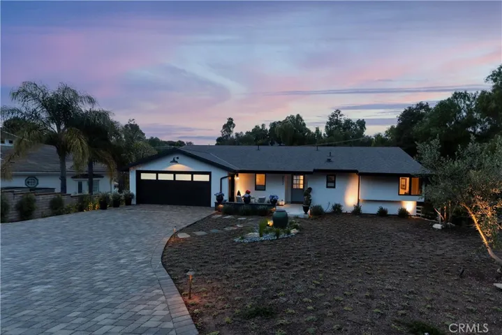 Soft, evening landscape lighting accents the ambiance of the outdoor space.