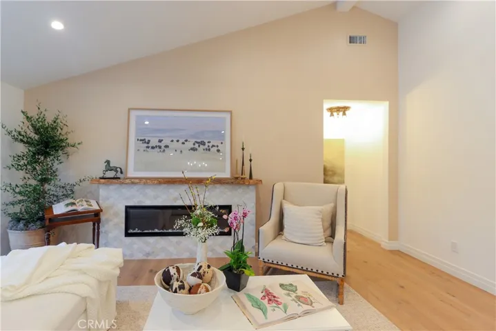 The living room fireplace is an inviting focal point for relaxing and entertaining. Unique tile and raw-edge, reclaimed wood mantle add character.