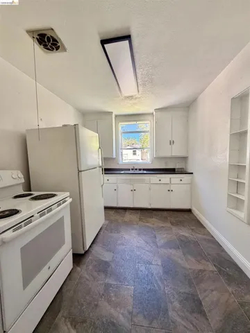 Kitchen featuring white cabinetry, a built-in sink, and laminate countertops