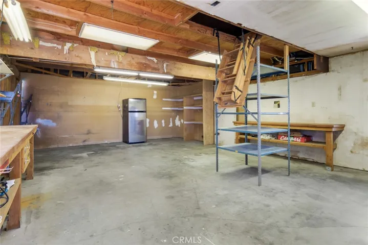 Workshop with garage access and ample attic space. Refrigerator stays with property.