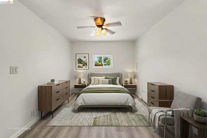Room featuring light-toned walls, wood-finish flooring, and a ceiling fan with integrated lighting