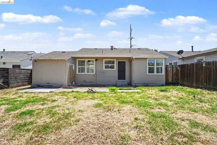 The property features a tan exterior with multiple windows and a dark entry door