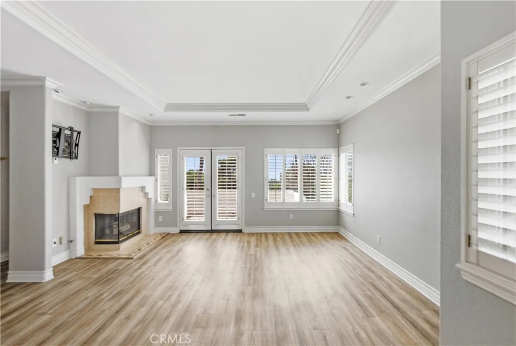 Living room view from entry way, corner gas fireplace, french doors to front balcony with ocean & Catalina Island views. Lots of windows, all with plantation shutters
