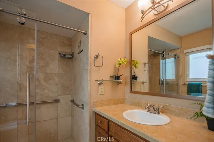 The walk in shower by the second sink has travertine walls