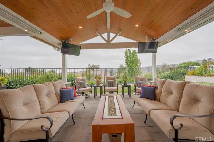 Covered lounging area has 2 monitors and a built in gas fire pit